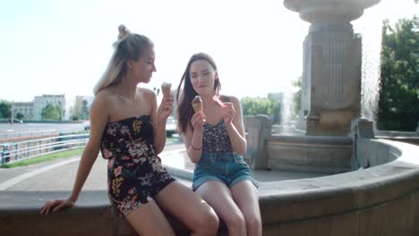 Dos-amigas-comiendo-helado-en-una-ciudad.