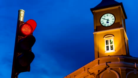 Semáforo-con-torre-del-reloj-en-el-color-del-atardecer-de-cielo-en-el-crepúsculo