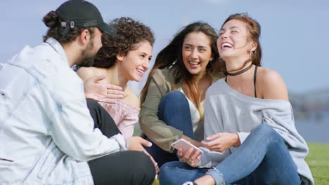 Grupo-multiétnico-de-jóvenes-fuera-de-divertirse-con-smartphone