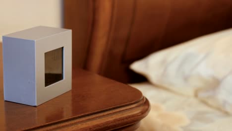 Electronic-alarm-clock-on-the-nightstand-in-the-bedroom