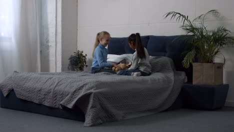 Niedliche-Multi-ethnischen-Mädchen-spielen-Spielzeug-auf-dem-Bett