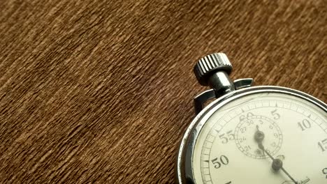 Vintage-White-Stopwatch-on-the-Brown-Structural-Background-Rotates-the-Arrow