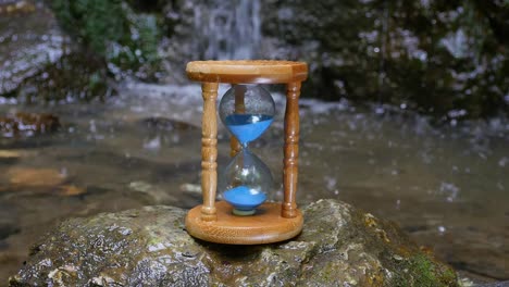 Hourglass-on-the-Background-of-a-Mountain-River