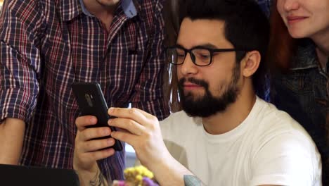 Gruppe-von-Freunden-mit-Smartphone-zusammen-in-der-Cafeteria