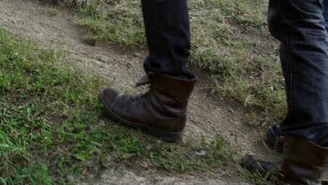 Legs-of-Unrecognizable-Hikers-Walking-on-Grass