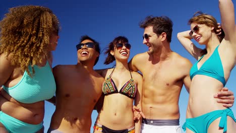 Happy-multi-ethnic-friends-in-swimsuits-on-beach