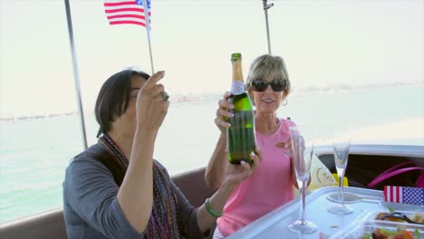 mujer-asiática-y-Caucásica,-celebrando-en-un-barco-con-champagne