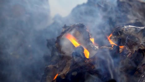 Slow-Motion-Rauch-von-Feuer-brennt-Müll-auf-dunklem-Hintergrund.