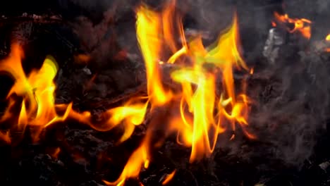 Slow-motion-smoke-of-fire-burning-garbage-on-dark-background.