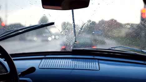 POV-vom-vorderen-Sitz-an-der-Windschutzscheibe-des-alten-Retro-Autos-bei-schlechtem-Wetter.-Scheibenwischer,-die-Regentropfen-aus-dem-Fenster-der-Oldtimer-Auto-während-der-Fahrt-auf-der-Autobahn-zu-entfernen.-Slow-Motion-hautnah