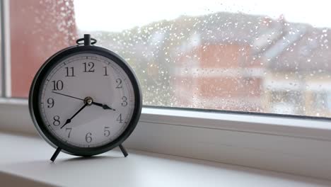 Antiguo-reloj-retro-contra-el-vidrio-de-la-ventana-con-la-lluvia-cae