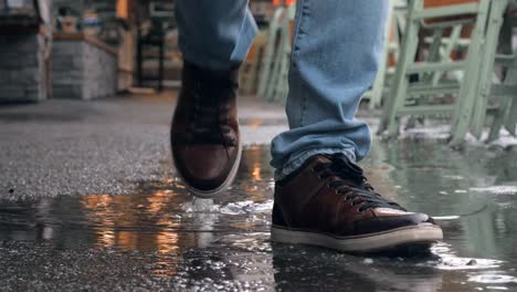 Feet-walk-through-puddle-on-rainy-day-at-outdoor-market