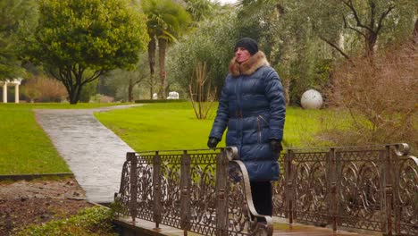 A-woman-in-rainy-weather-on-a-small-bridge