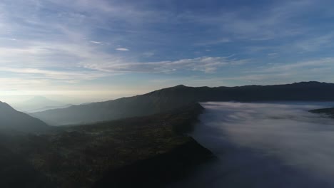 Aerial-view-flight-over-Cemoro-Lawang,-small-village-in-morning-mist