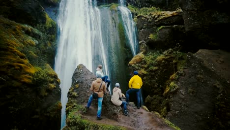 Vista-aérea-del-grupo-turístico-descansando-en-la-cima-de-la-montaña-y-mirando-en-la-cascada-de-Gljufrabui-en-Islandia