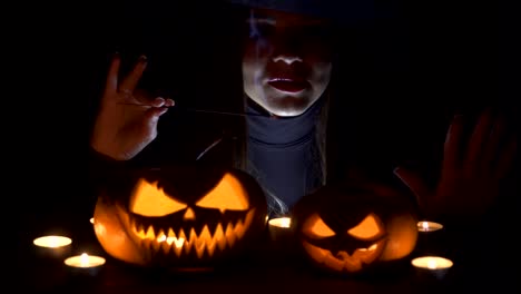 Halloween-Witch-with-a-magic-Pumpkin.-Beautiful-young-woman-in-witches-hat-and-costume-holding-carved-pumpkin.-Halloween-art-design