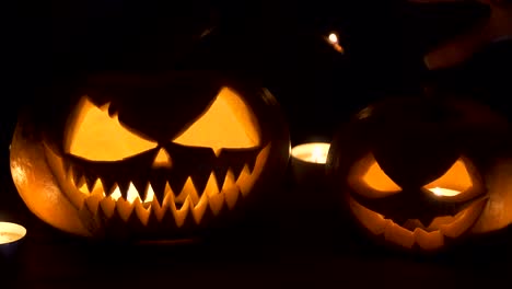 On-the-main-terms-of-the-pumpkin,-witch-casts-a-spell-from-behind..-Beautiful-young-woman-in-witches-hat-and-costume-holding-carved-pumpkin.-Halloween-art-design