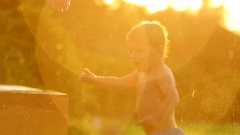 Verträumte-60fps-Zeitlupen-Szene-Säugling-Baby-jungen-Spaß-mit-Wasser-besprengt-während-des-Sonnenuntergangs-goldene-Stunde-Mal-in-4-k-Clip-Auflösung.-Babys-genießen-die-einfachen-Dinge-des-Lebens-in-4K