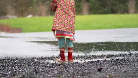 Young-girl-with-umbrella-playing-in-rain,-slow-motion