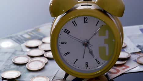 Alarm-clock-on-coins-and-banknotes