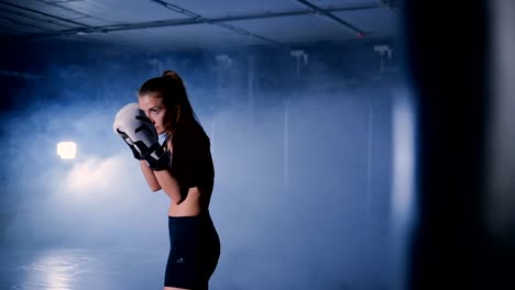 Schöne-Kickboxen-Frau-in-Boxhandschuhen-im-Fitness-Studio