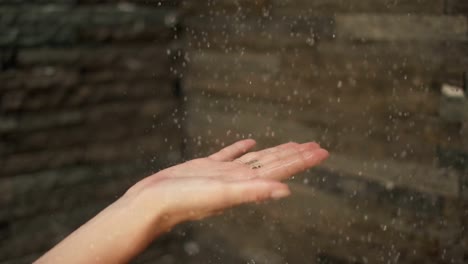 Turning-on-of-the-Shower-Woman-Places-Her-Hand-under-Stream-of-Water.-Droplets-Landing-on-Her-Palm.