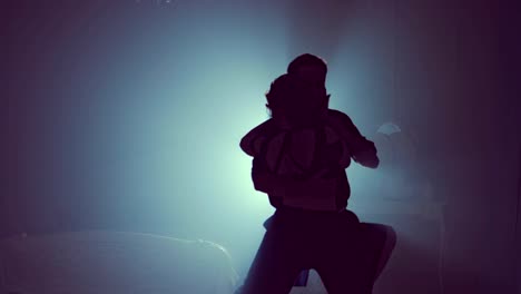 Final-point-in-dances-performed-by-two-ballroom-dancers.-Silhouette-in-smoky-studio