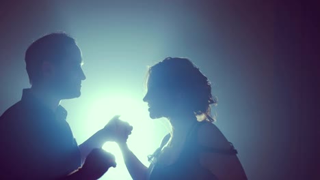 Dancers-in-love-cling-to-each-other-at-the-end-of-the-dance.-Silhouette-couple-ballroom.-Smoke