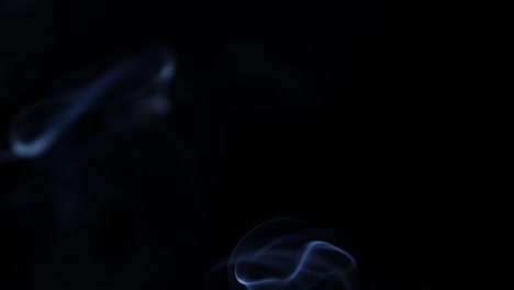 smoke-slowly-floating-through-space-against-black-background.