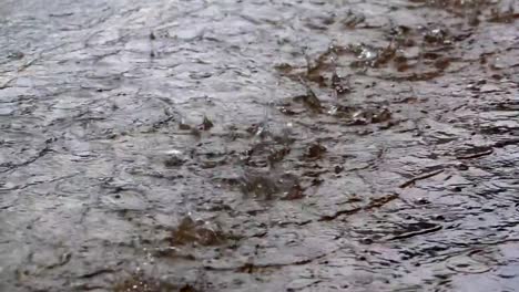 Slow-motion-raining-droplets-on-ground-heavy