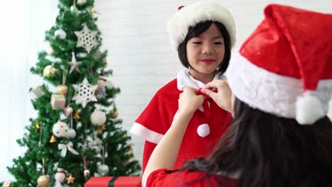 mother-helps-her-cute-kid-girl-to-tie-Bow