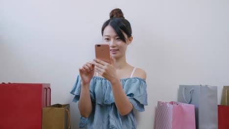 Woman-using-cellphone-while-shopping