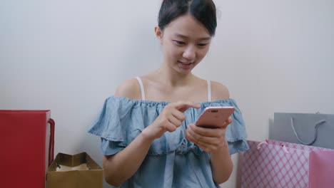 Woman-using-cellphone-while-shopping