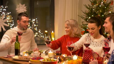 happy-friends-drinking-red-wine-at-christmas-dinner