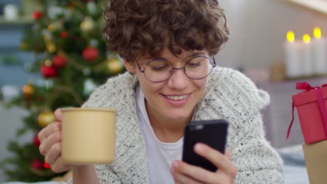 Happy-Woman-with-Mobile-Phone-at-Christmas