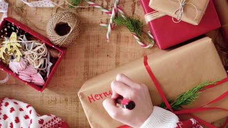 Woman-writing-'Merry-Christmas'-on-the-christmas-present