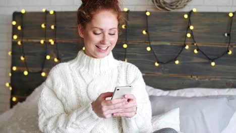 Girl-using-a-mobile-phone-in-her-bed