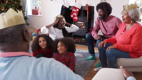 Multi-Generationen-Familie-sprechen-und-Geschichten-zu-erzählen,-wie-sie-Weihnachten-zu-Hause-zusammen-feiern