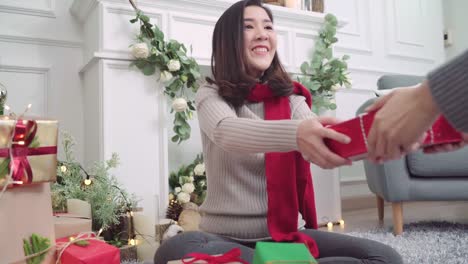 Lesbian-Asian-couple-giving-christmas-gifts-to-each-other-in-her-living-room-at-home-in-Christmas-Festival.-Lifestyle-lgbt-women-happy-celebrate-Christmas-and-New-year-concept.