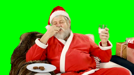 Santa-Claus-entspannen-auf-Couch-und-süße-Speisen