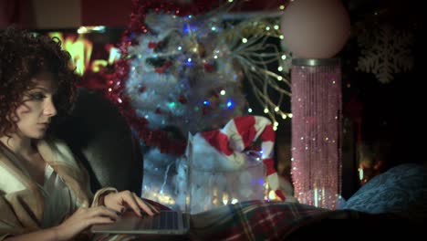 4k-Christmas-and-New-Year-Holiday-Woman-Working-on-Laptop-at-Fireplace