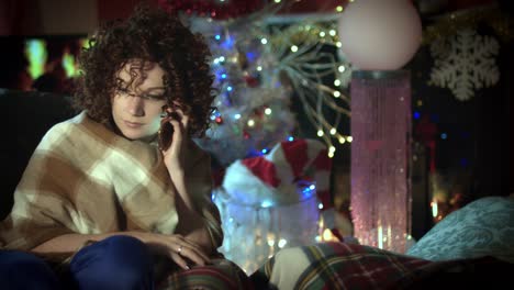 4k-Christmas-and-New-Year-Holiday-Woman-Talking-on-Phone-at-Fireplace