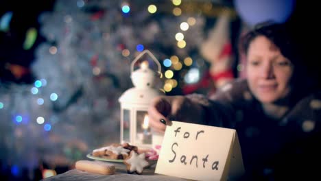 4k-Christmas-and-New-Year-Holiday-Woman-Putting-Letter-for-Santa-and-Cookies