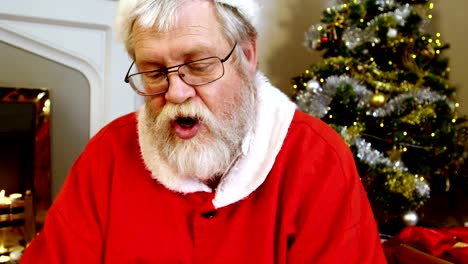 Santa-claus-sitting-near-fireplace