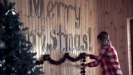 Young-woman-putting-up-Christmas-decorations