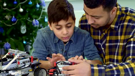 Father-and-son-examine-toy-tracked-ATV