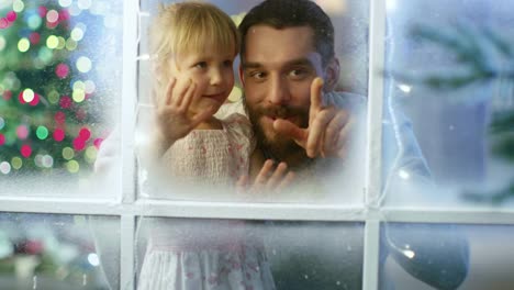 On-Christmas-Eve-Father-and-His-Cute-Daughter-Looks-Through-the-Snowy,-Frozen-Window-and-Smile.
