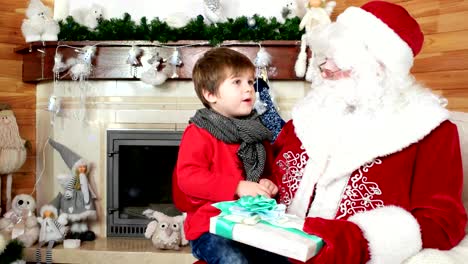 niño-diciendo-santa-sus-deseos-de-Navidad,-niño-sentado-en-el-regazo-de-San-nicolas,-gran-regalo-para-niños