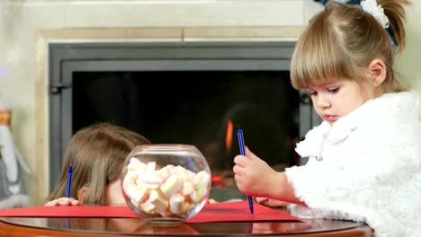 niño-algo-ha-concebido,-chica-con-cara-de-sly-se-asoma-por-detrás-de-su-escritorio,-niñas-dibujar-un-lápiz-sobre-una-hoja-de-papel