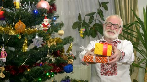 Netter-Alter-Mann-hält-in-der-Nähe-der-Weihnachtsbaum-Weihnachtsgeschenke